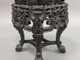 an ornately carved table with a bowl on top of it