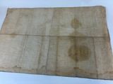 an old piece of paper with stains on it sitting on a table