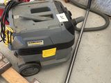 une photo d'un aspirateur posé par terre dans un garage