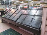 a large display case in a grocery store filled with fruits and veggies