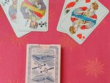 plusieurs cartes à jouer posées sur une table recouverte d'un napperon rose