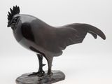 statue of a rooster on a rock on a white background