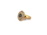 a close up of a gold ring with a blue and white diamond
