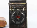 a small black box with a clock on it next to a pair of brown shoes