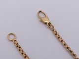 a close up of two gold chains on a white surface