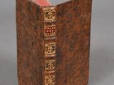an old book sitting on top of a table next to a gray wall