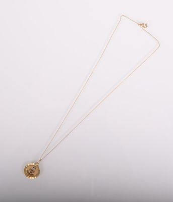 un collier en or auquel est suspendue une pièce de monnaie sur le côté