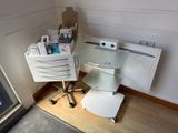 un bureau en verre sur lequel est posé un ordinateur, dans une pièce