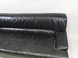 black leather couch with gold piping on the arms and legs