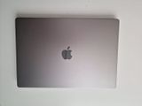 a silver apple laptop sitting on a white table