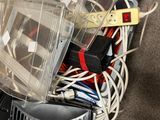 a pile of electronics on the floor next to a laptop