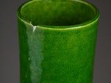 a green vase that is sitting on a table