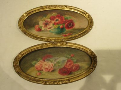 two oval paintings with flowers on them on the wall