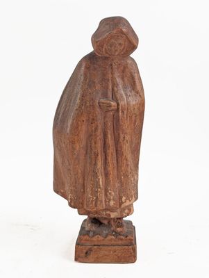 an old wooden statue of a man with a hat and robe
