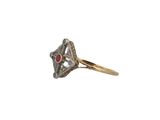 a close up of a gold ring with a diamond and a ruby stone