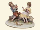 a figurine of two children sitting on a rock