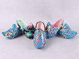 three pairs of clogs with colorful floral designs on them