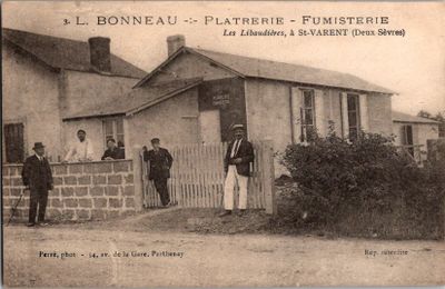 une vieille photo montrant un groupe d'hommes debout devant une maison
