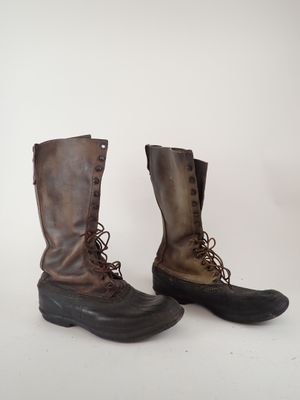 pair of brown leather boots with laces on them on a white surface