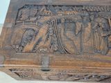 a wooden box with carvings on it sitting on a table