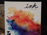 a box of ink next to a clock on a table