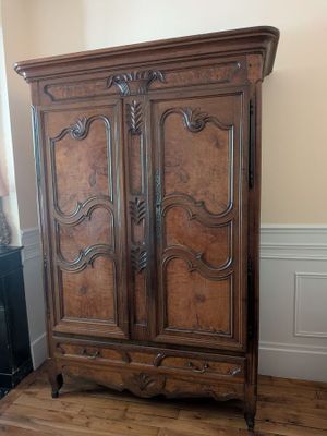 a wooden armoire in the corner of a room