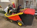 a red and yellow lawn mower sitting on the ground