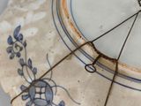 a blue and white plate with a clock on it
