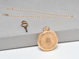 a close up of a gold locke with a key on a table