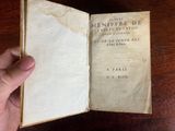 someone is holding a book open on a wooden table