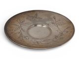 an antique silver plate with a bird design on the rim