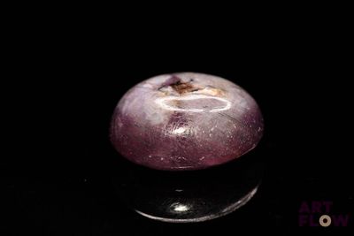 a purple apple that is sitting on a black surface