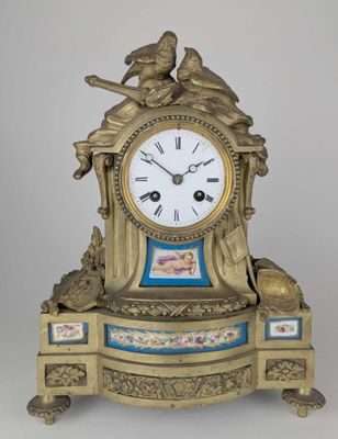 une horloge posée sur une table, sur laquelle se trouve un oiseau