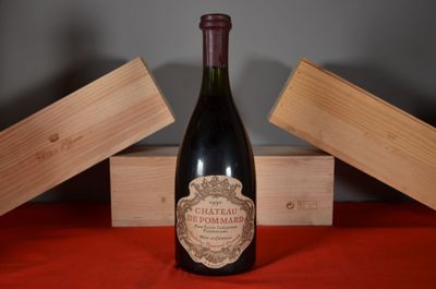 a bottle of wine sitting on a table next to a wooden box