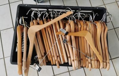 a lot of wooden clothes hangers in a black container