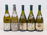 six bottles of wine are lined up in a row on a white surface