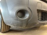 a close up of a car ' s front bumper with a hole in it