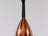 a wooden mandolin hanging from a string on a white wall