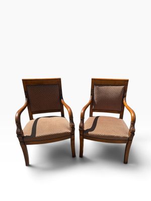 two wooden chairs with upholstered arms and a brown upholstered seat