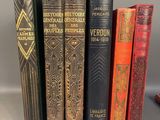 several old books are lined up on a shelf in front of a gray background