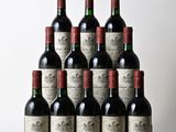 a bunch of bottles of wine sitting on top of a wooden table