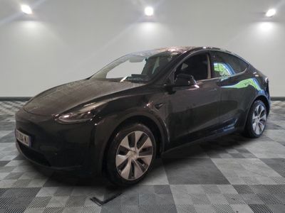 une photo d'une Tesla Model Y noire garée dans un garage
