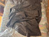 a black leather jacket and pants on a bed