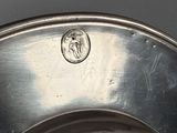 a silver bowl with a coin on the bottom