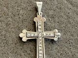 a silver cross on a table with a price tag attached to it