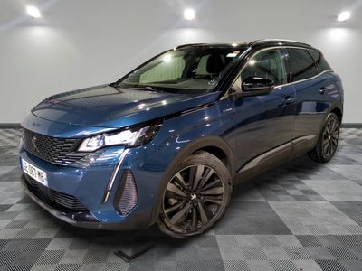 le 4x4 bleu est garé sur le sol en damier d'un garage