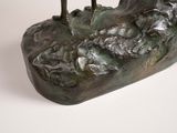 a bronze sculpture of two birds perched on a rock