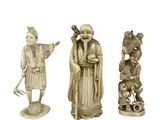 three chinese carved figurines of a man and a woman