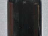 a bottle of wine sitting on a table with a bottle of wine in front of it