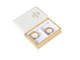 two gold wedding rings in a gift box on a white background